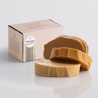 A stack of creamy caramel fudge in an elegant buff-coloured gift box with gilded accents and a congratulations box seal.