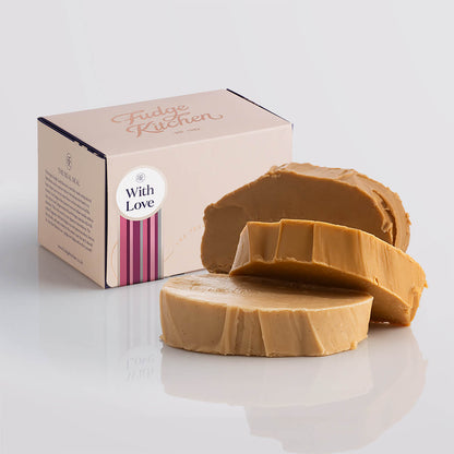 A stack of creamy caramel fudge in an elegant buff-coloured gift box with gilded accents and a with love box seal.