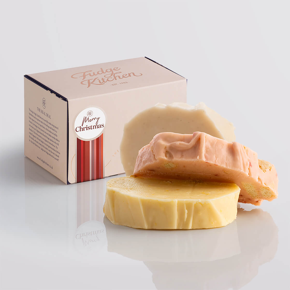 Fruity fudge trio elegantly packaged in a buff-coloured gift box with gilded accents and a 'Merry Christmas' box seal.