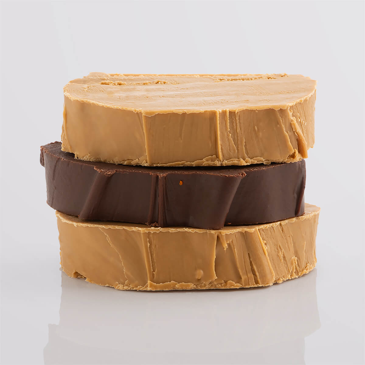 A stack of creamy vegan fudge slices in warm, rich tones.